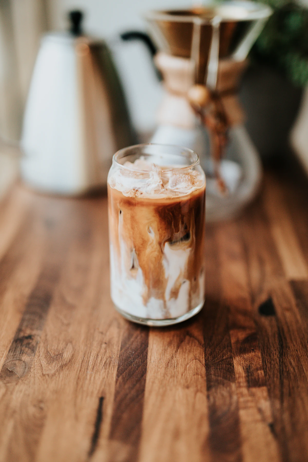 Iced latte with milk swirling into espresso
