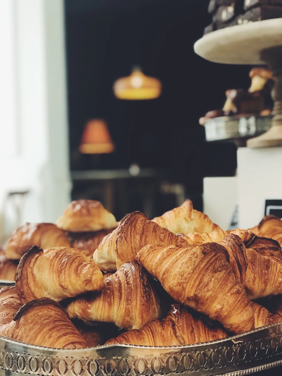 A pile of golden croissants on the counter