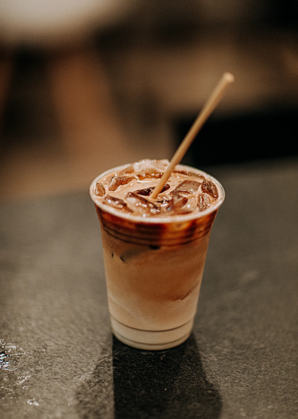 Iced coffee with a paper straw on a table